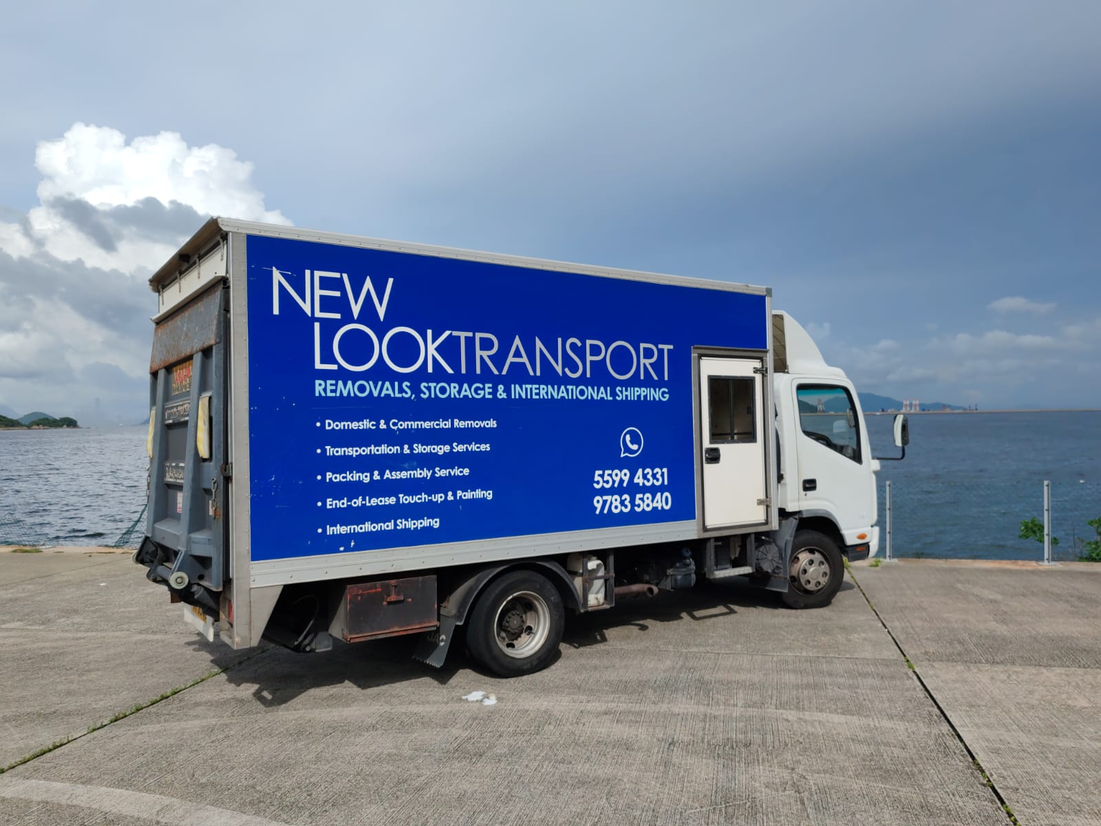 New Look Transport truck loaded with wrapped furniture, tail lift down