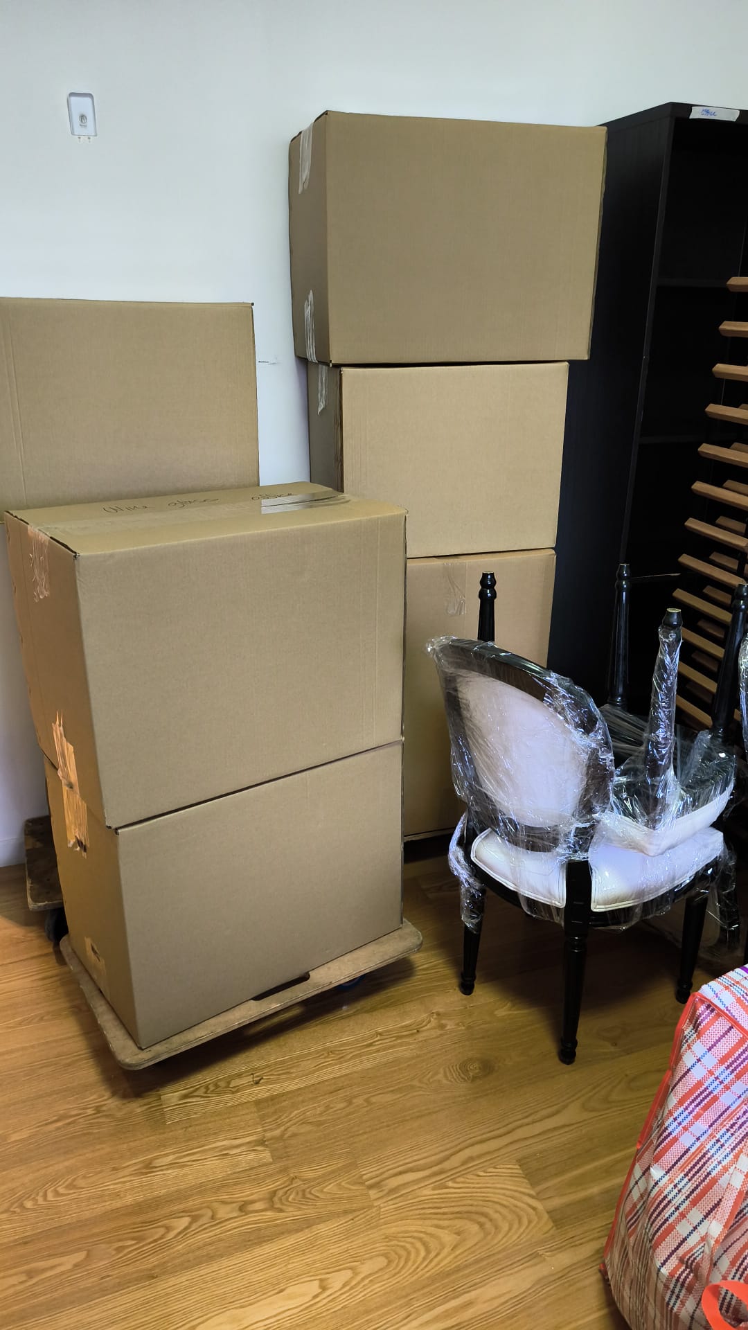 Packed boxes and shrink-wrapped chairs ready for a move