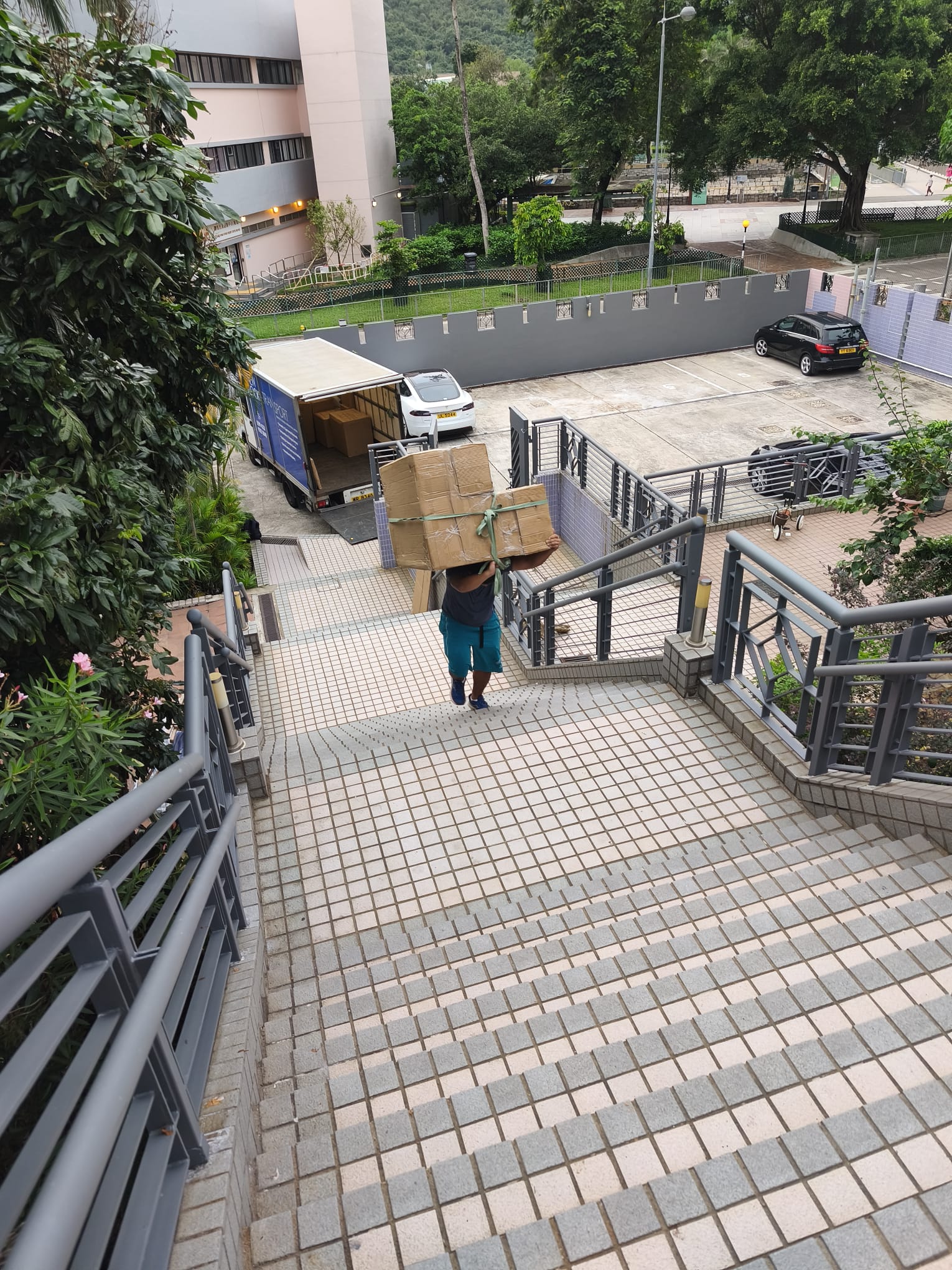 Crew member carrying boxes down stairs to the removal truck