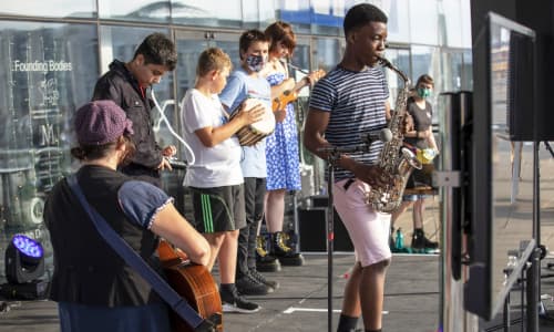 a young band on stage playing musical instruments