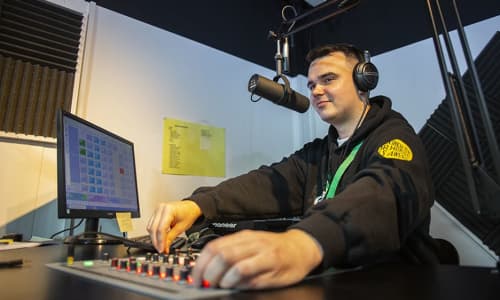 Young man sat in a radio studio