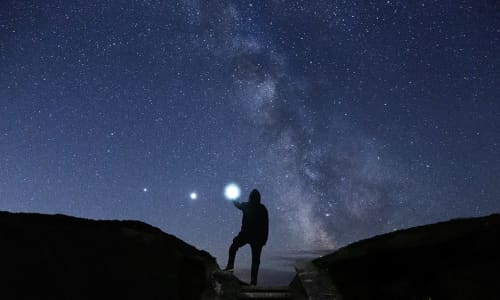 Person stood in silhouette with the the Milky way in the sky at nigh