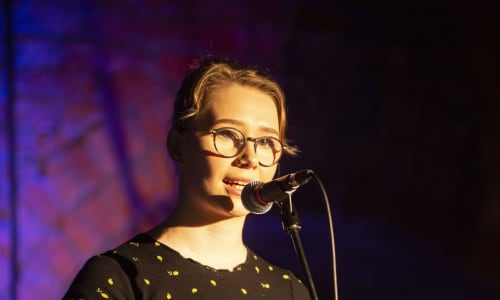 Ayoung woman stood talking into a microphone