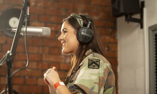 A young woman singing into a microphone