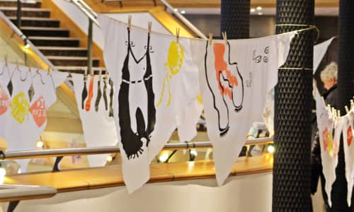 Colourful artwork painted on white cloth hung from line