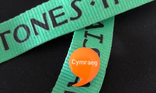 The Work Welsh badge pinned onto a green lanyard