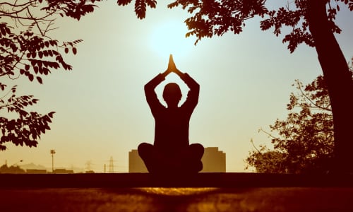 A person meditating in the sunlight by Prasanth Inturi.