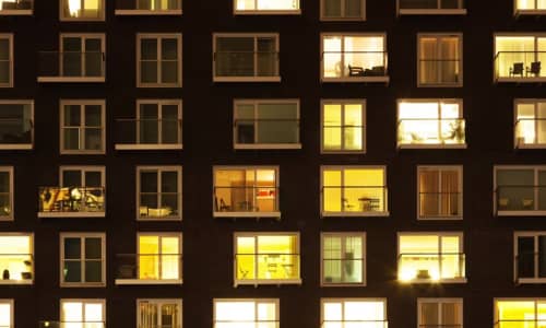 A block of flats at night with the windows lit