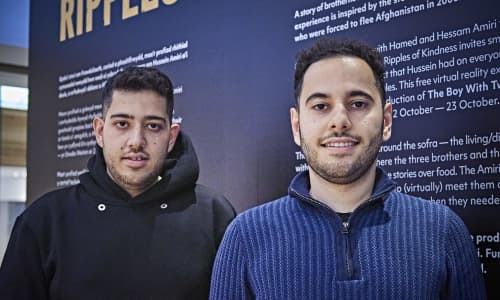 Two Afghan men stood smiling for a photograph