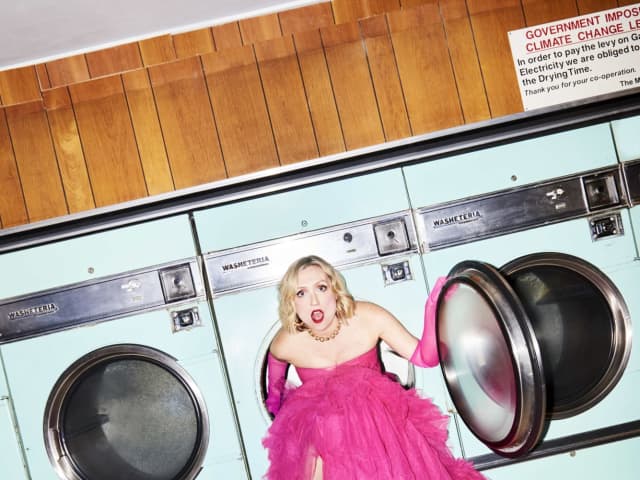 Eleanor Conway coming out of a washing maching in a big pink dress.