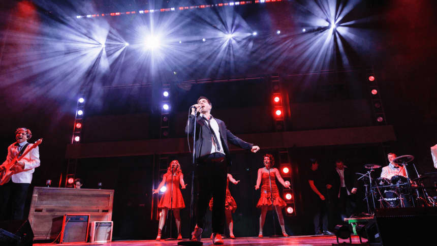 Man singing under 4 spotlights