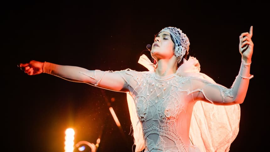 Bat For Lashes is wearing an ornate white lace bodysuit and headdress as she performs at Llais 2023.