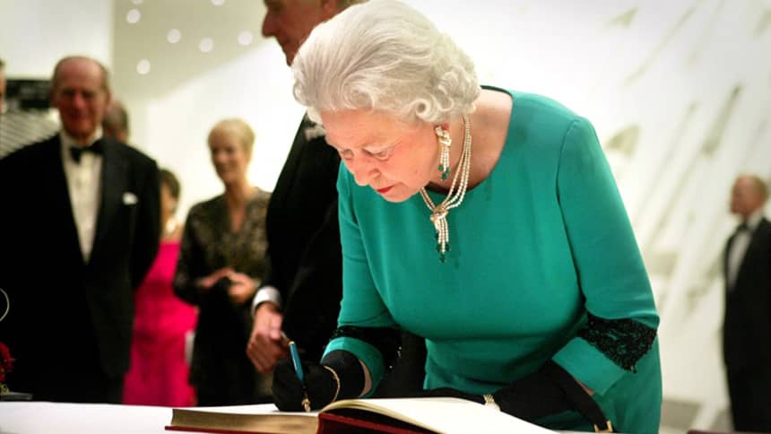 Y Frenhines yn arwyddo’n llyfr ymwelwyr/ The Queen signing our guest book