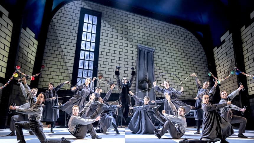 Large group of dancers dressed in black in various poses