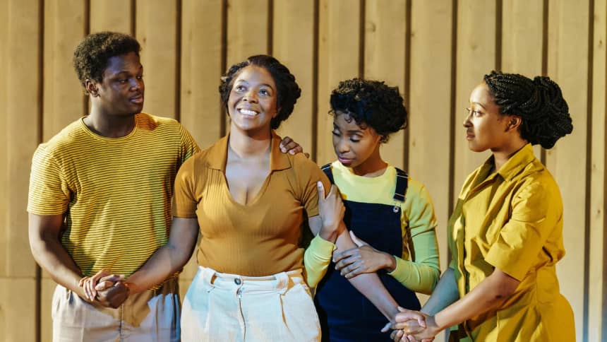 A woman looking happy with outstretched arms, surrounded by family