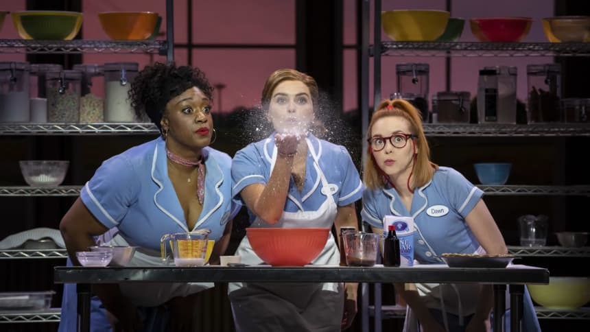 Three waitressed together with the centre waitress ( Jenna ) blowing flour into the air 