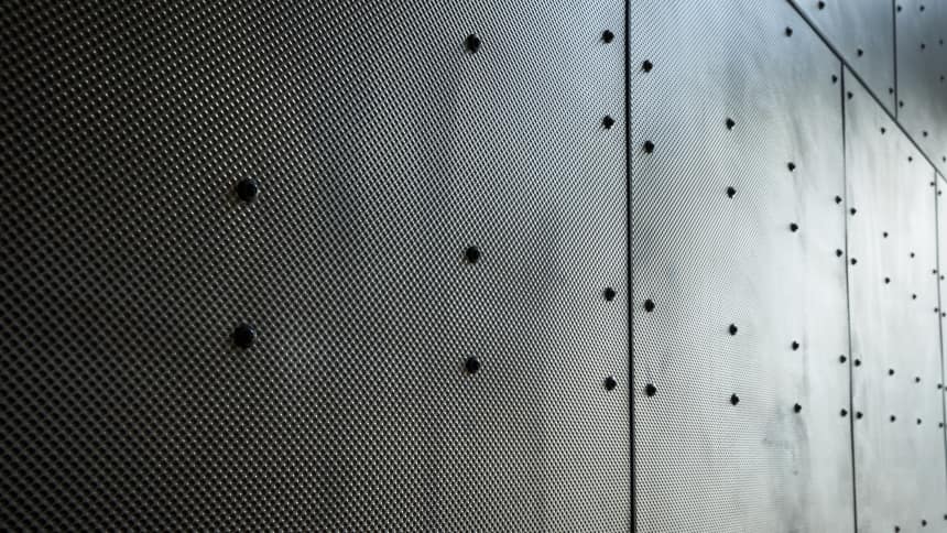 The stainless steel panels used on the roof also feature inside the building but are untreated and feature screws resembling the rivets found on a ship's hull