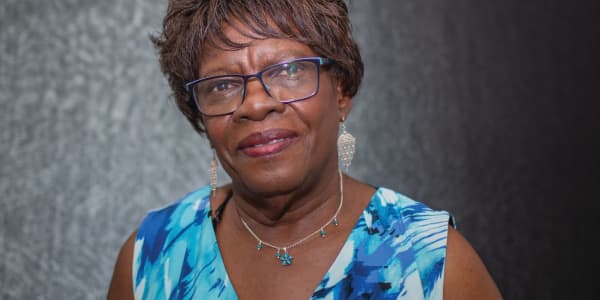 An older Black lady in a blue dress
