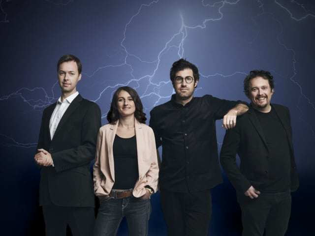 The four presenters of No Such Thing As A Fish stood in a row with a stormy background with thunder