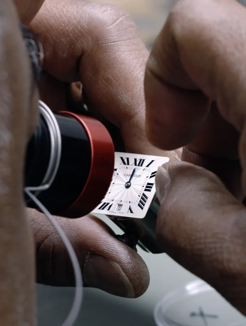 A watchmaker opening a caseback on the bench