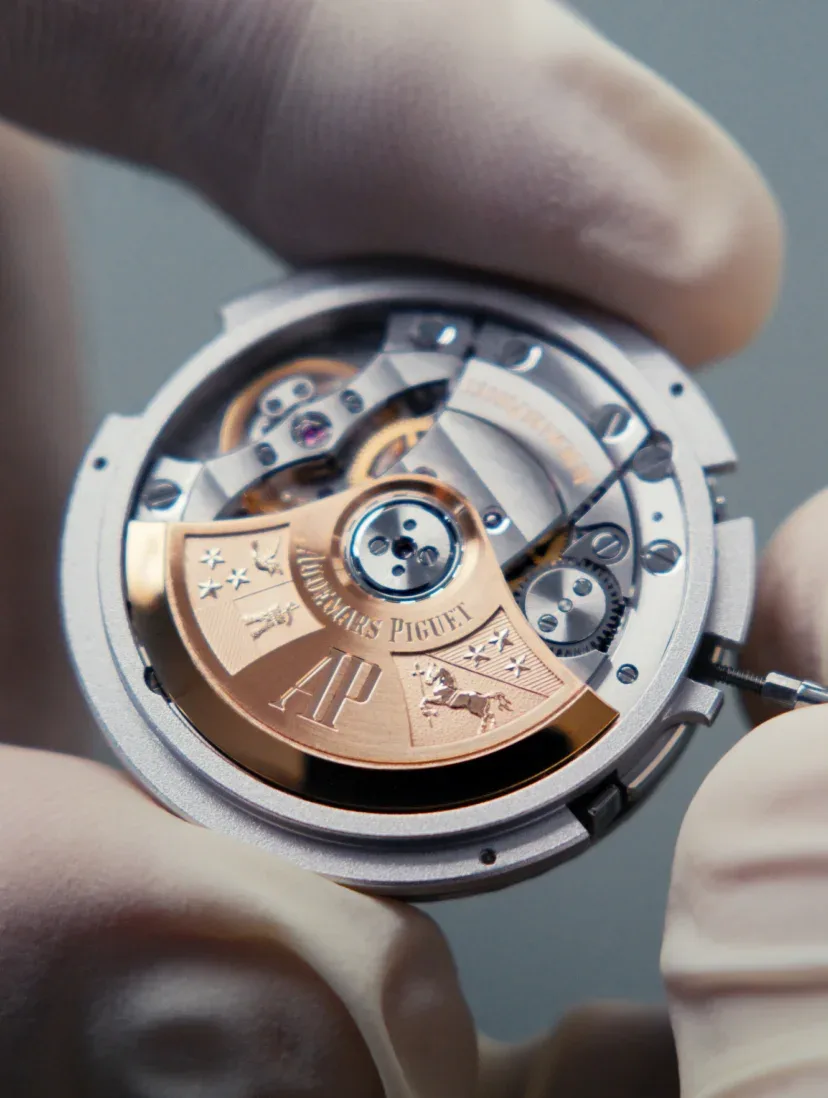 A gloved hand holding a serviced dial to the light