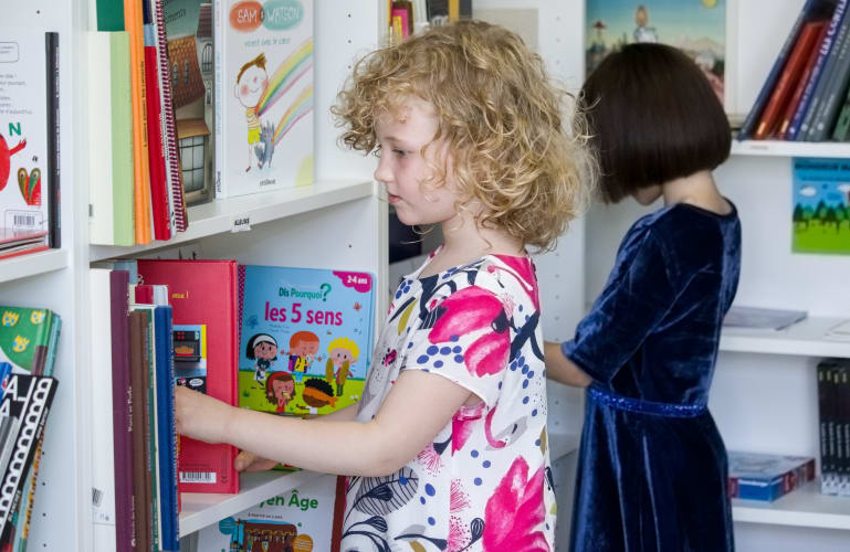 Une petit fille entrain de choisir un livre 