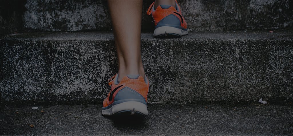 Legs in athletic shoes walking up stairs.