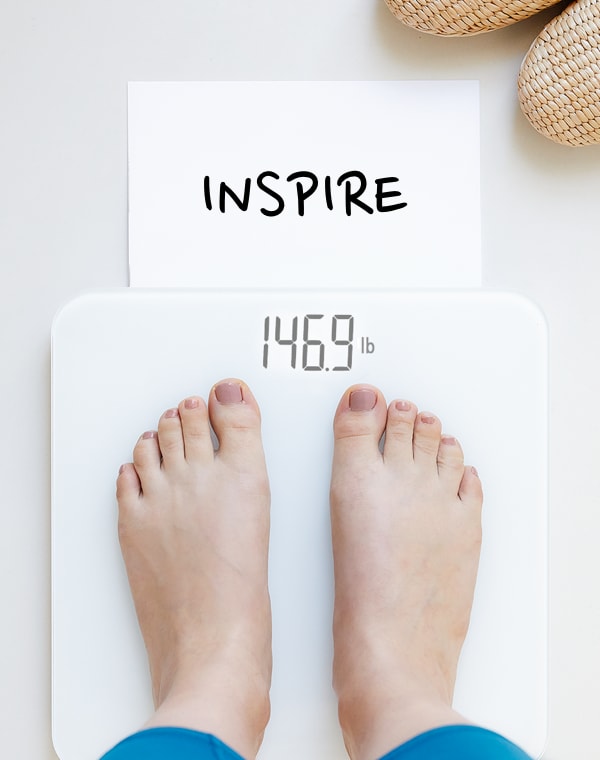 Feet on a while scale with the weigh in word "inspire"