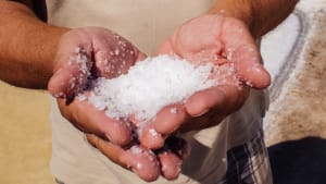 A close up of coarse sea salt in a person's hands