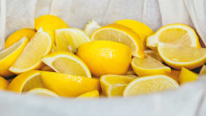 Lots of lemon quarters being infused in a white muslin cloth