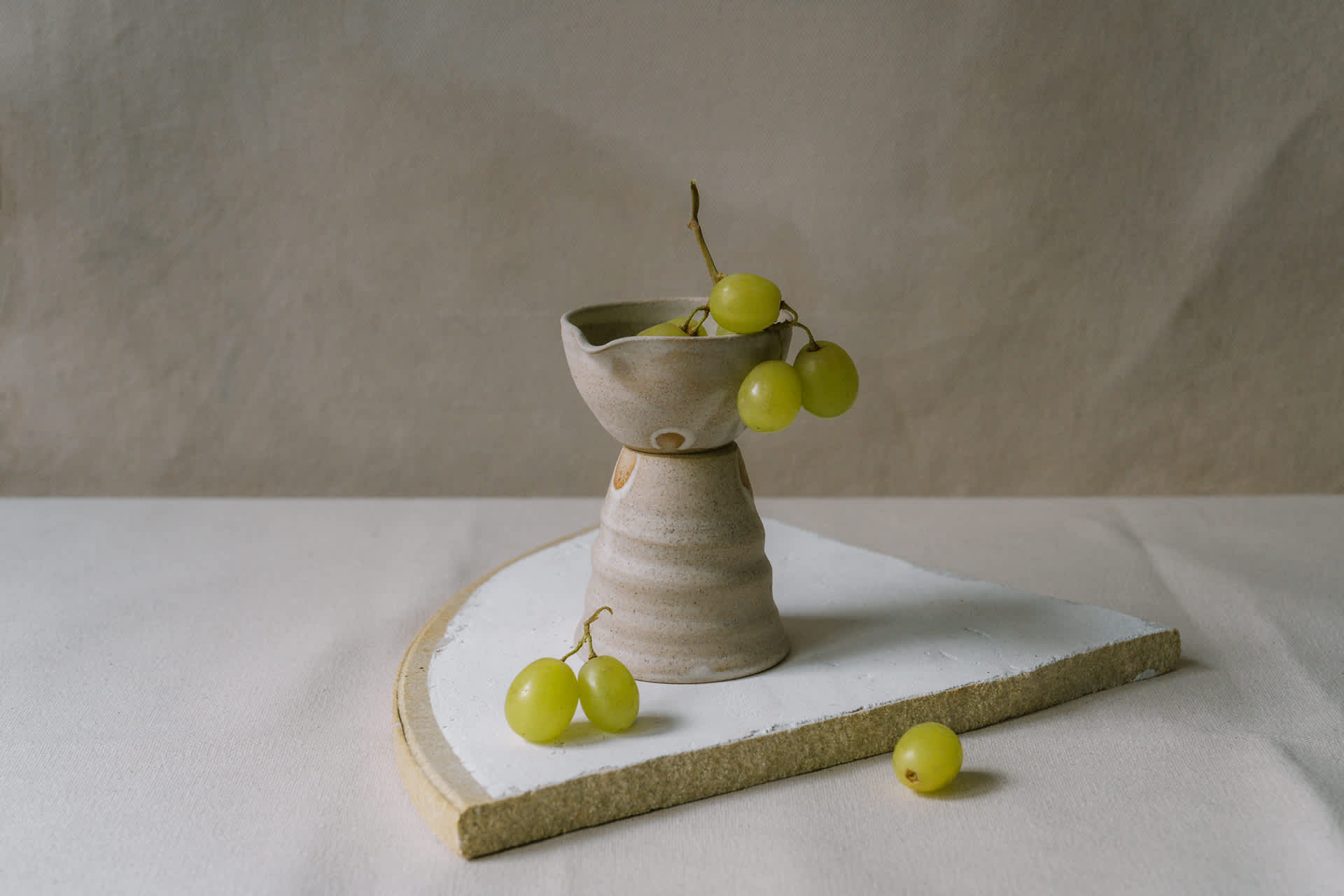 Ceramic milk pourer filled with grapes