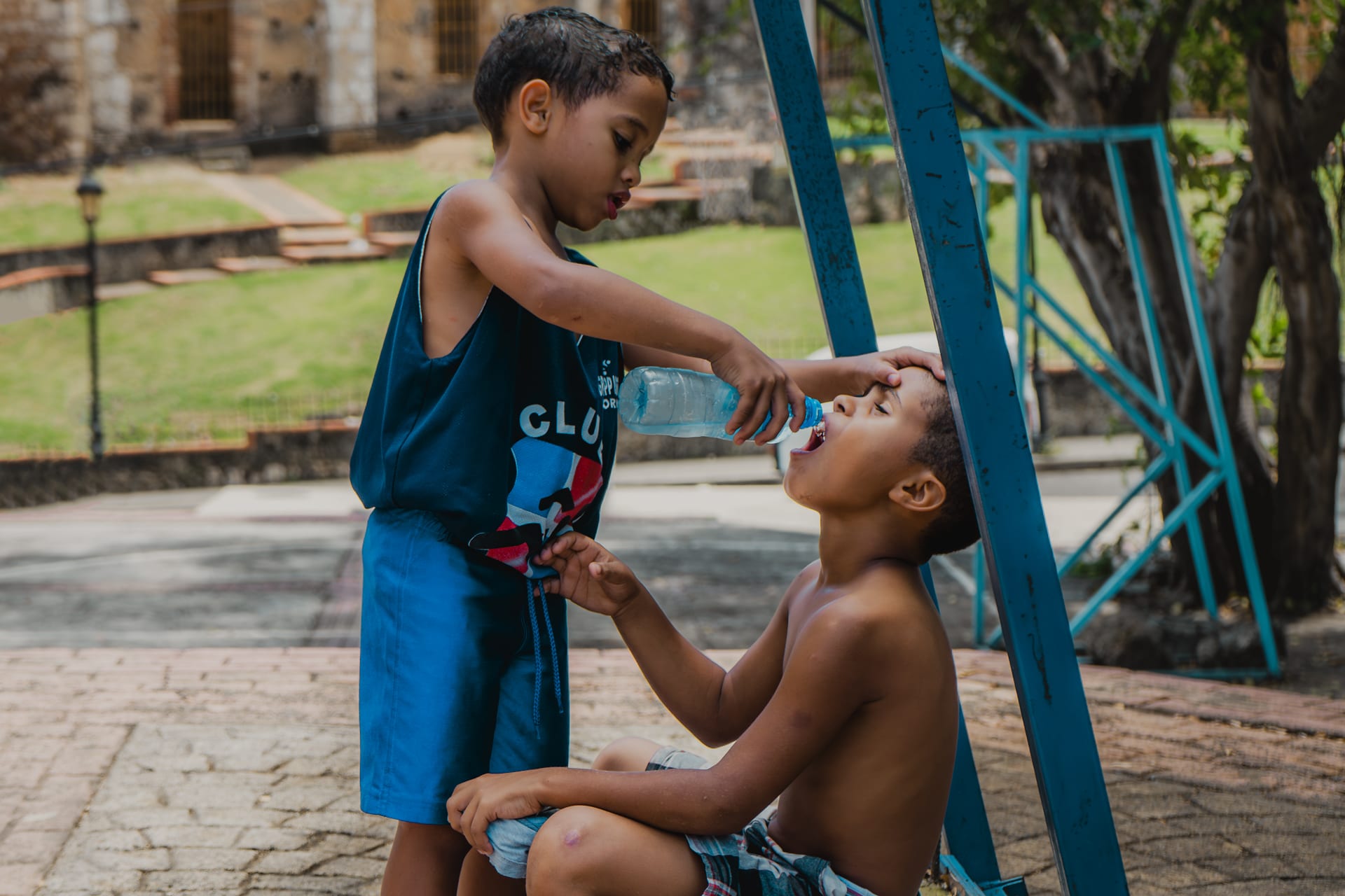 Child helping his friend to drink water