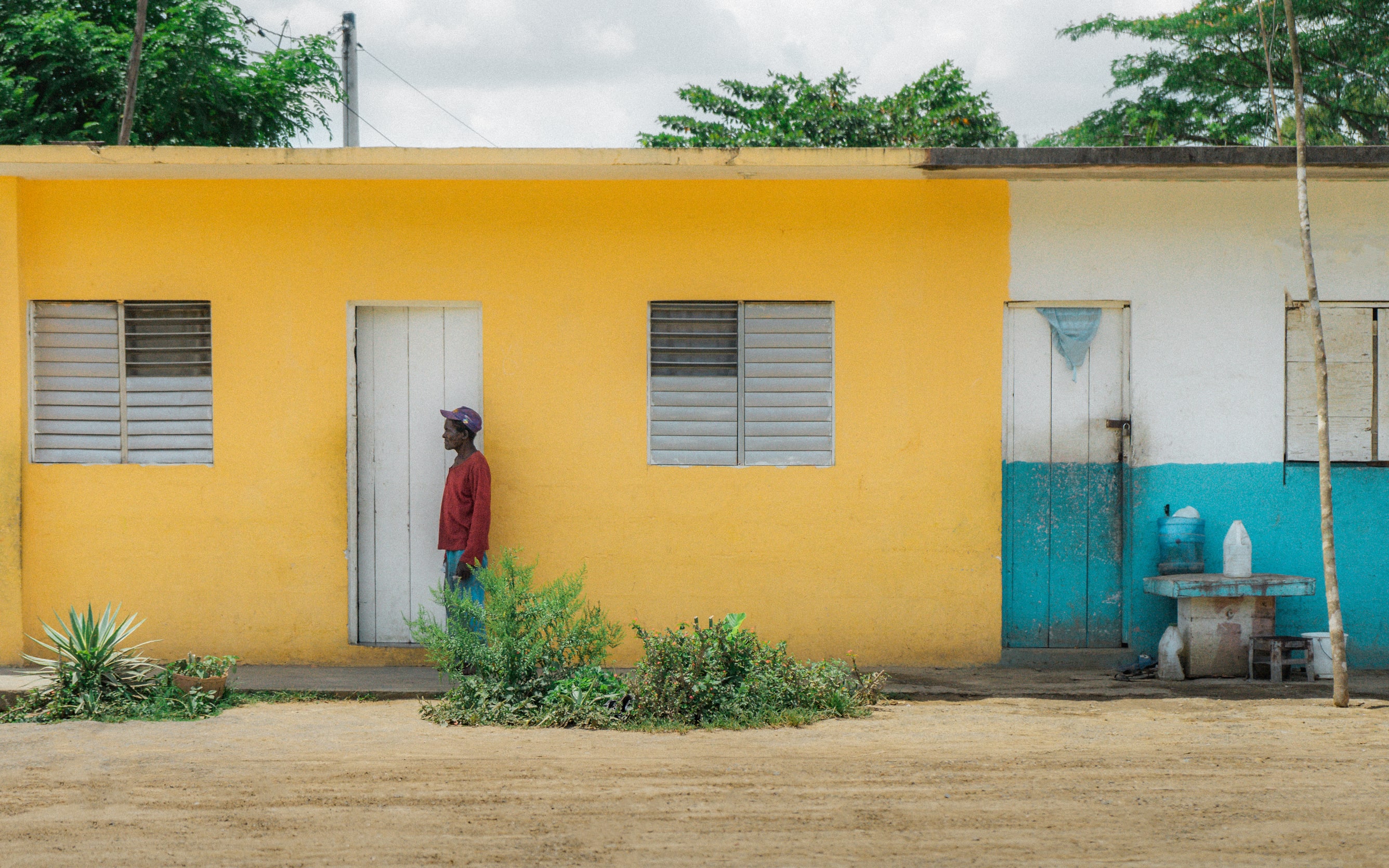 Man standing in front of a yellow wall and a white door