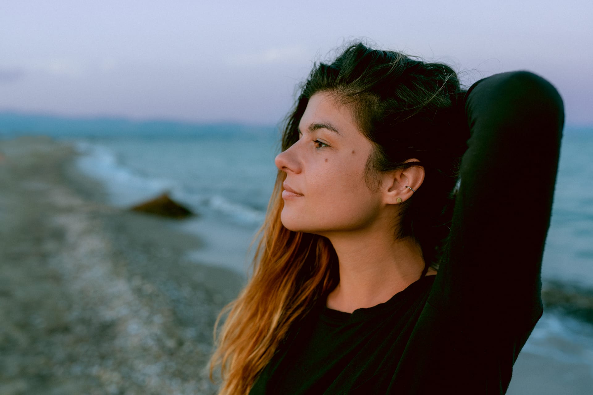 Portrait of a girl standing on a pebble beach by the sea