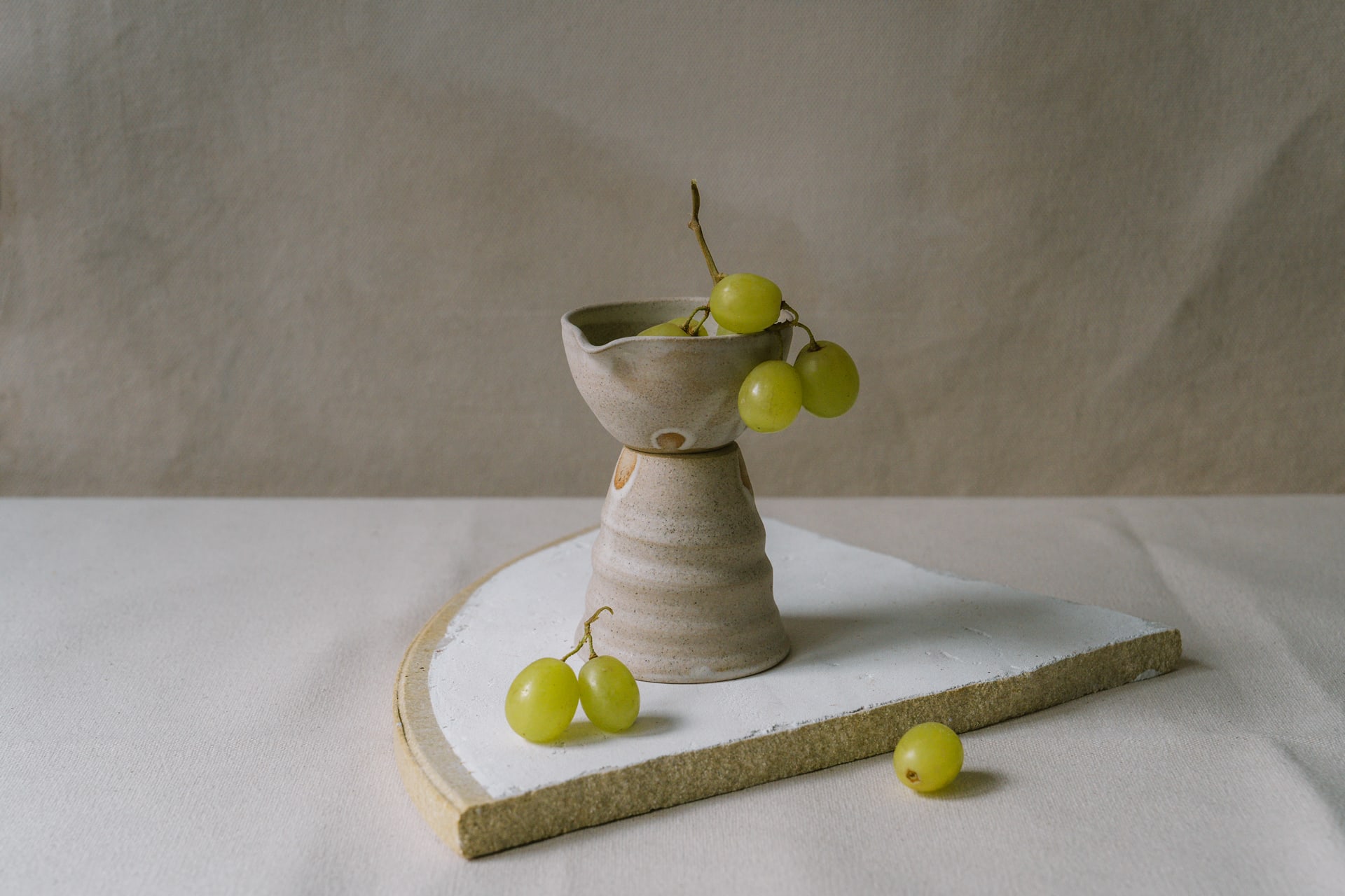 Ceramic milk pourer filled with grapes