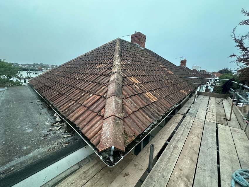 Weathered tiled roof and adjoining flat roof before replacement by Alpine Home Maintenance Ltd in Southmead, Bristol