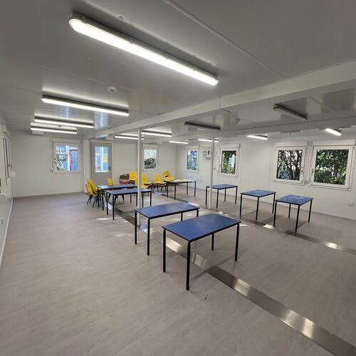Commercial electrician installing new electrical supplies in a school classroom
