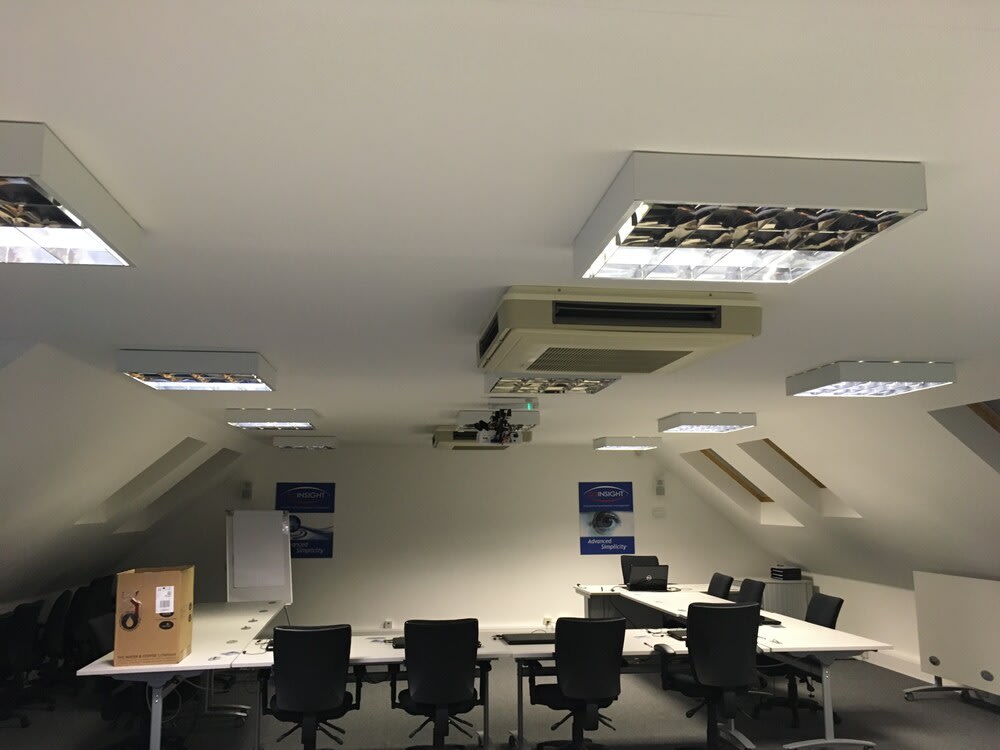 Commercial electrician performing electrical installation in a business office.