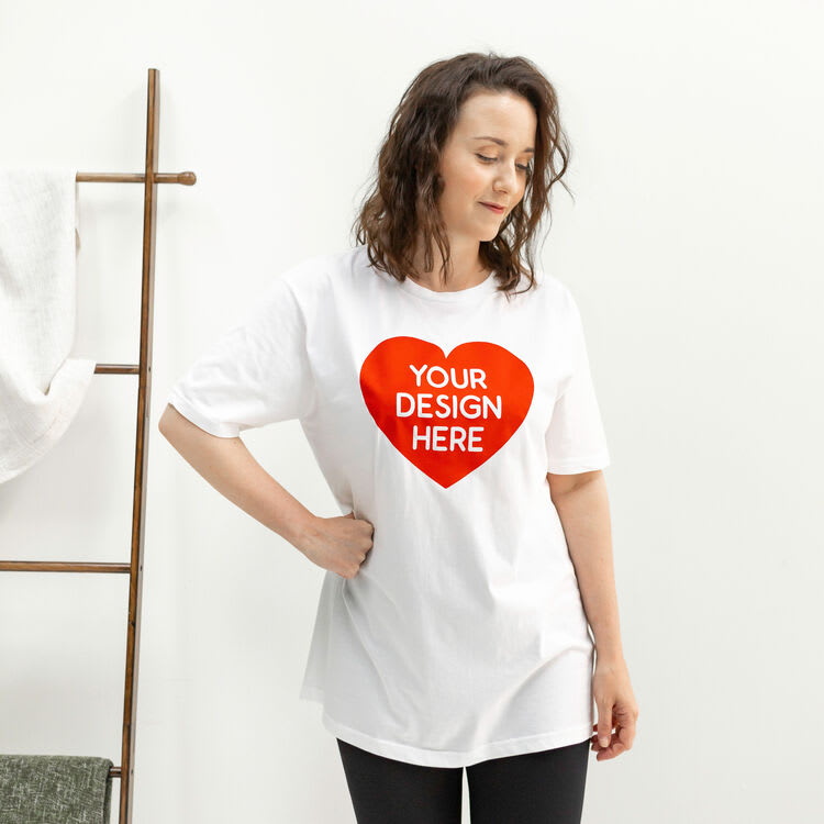 Woman wearing custom white t-shirt with red heart and “Your Design Here” text, personalised with vinyl heat transfer (HTV) printing.