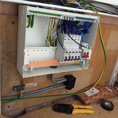 Certified electrician conducting an EICR in a living room setup\r\n