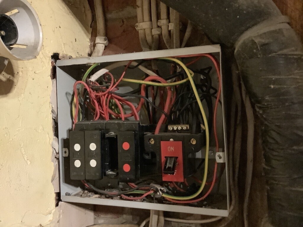Older electrical board with its cover removed, showing wiring and fuse equipment at the Winchester pub