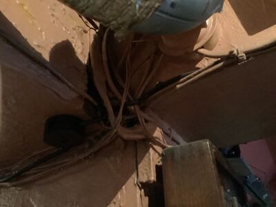 Existing cable routes at a wall and beam junction before the rewire.