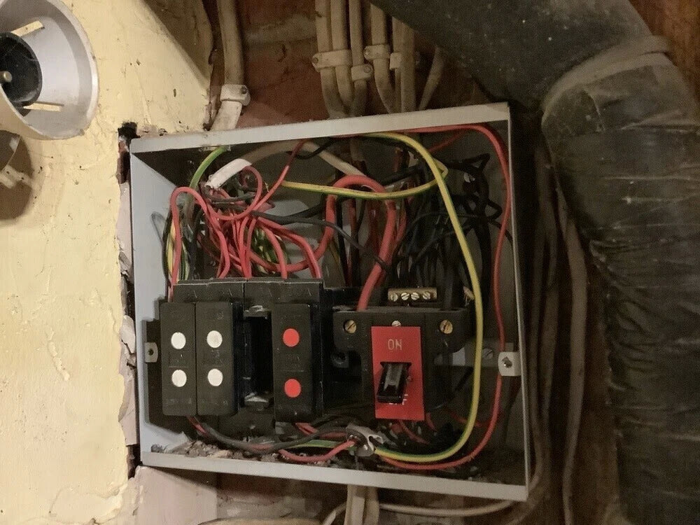 Wiring and older protective equipment inside a distribution board at the pub