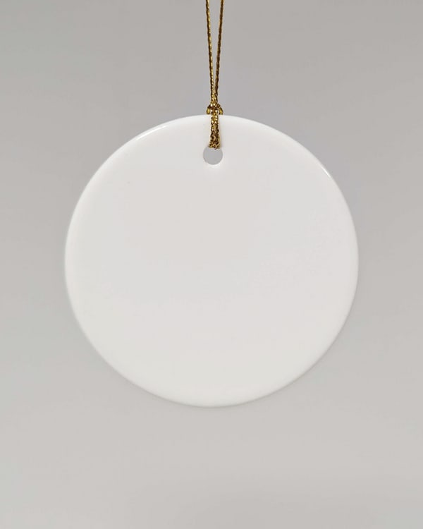Blank white ceramic ornament with gold string, ideal for custom printing, holiday crafting, or personalised eco gifts.