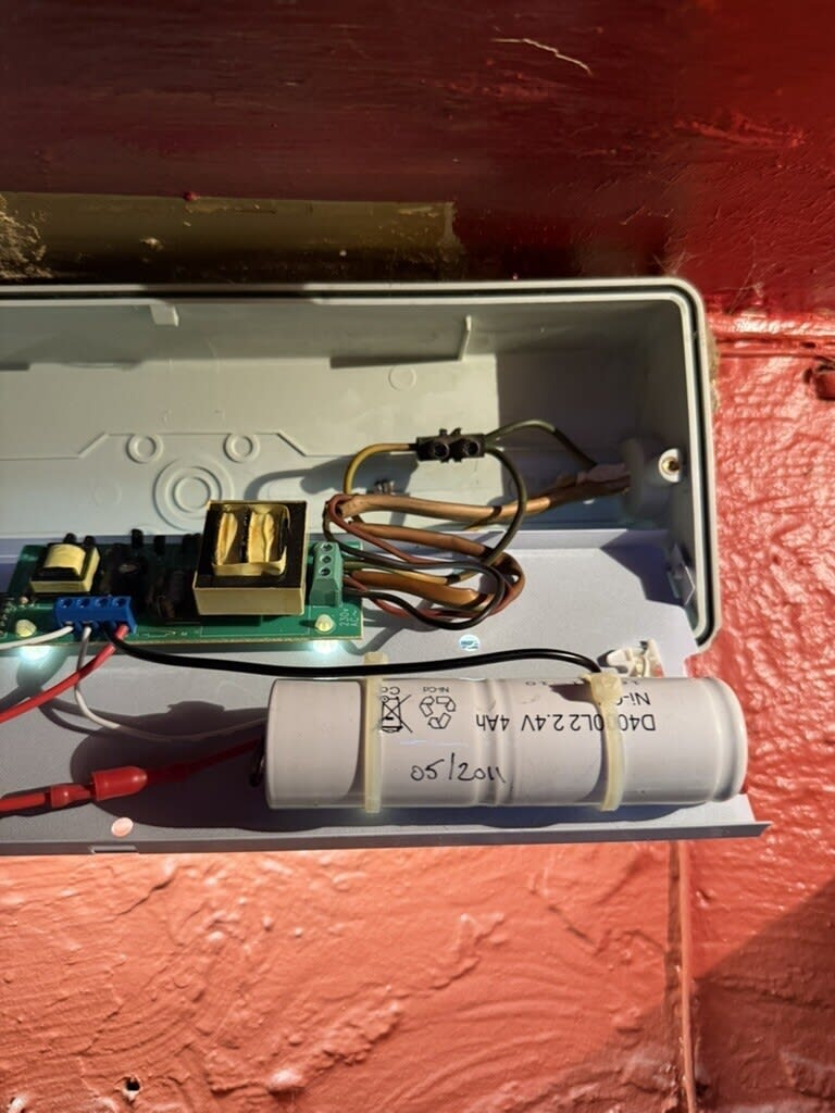 Interior of the pub’s emergency light showing its wiring, battery and components