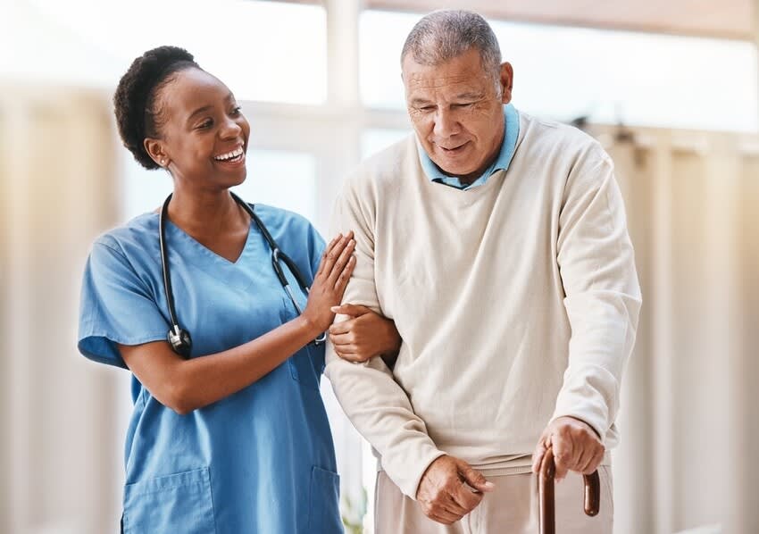 Young physiotherapist with elderly patient at home