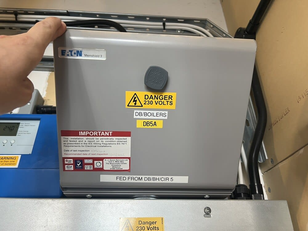 Commercial electrician inspecting electrical wiring and circuit breakers in a Southampton business premises