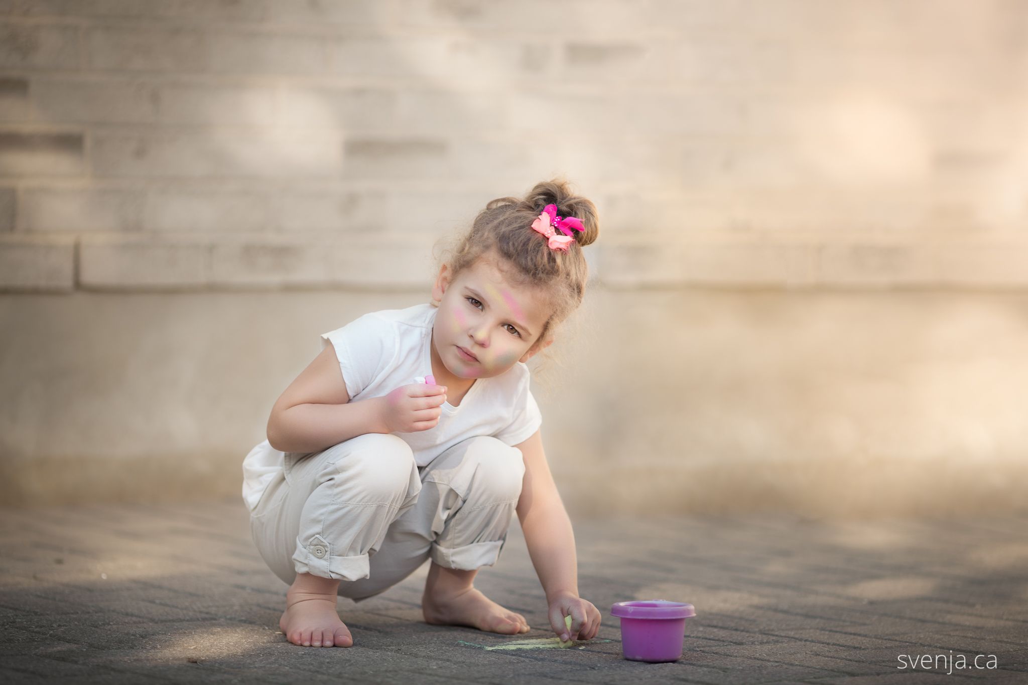 a little girl playing with sidewalk chalk