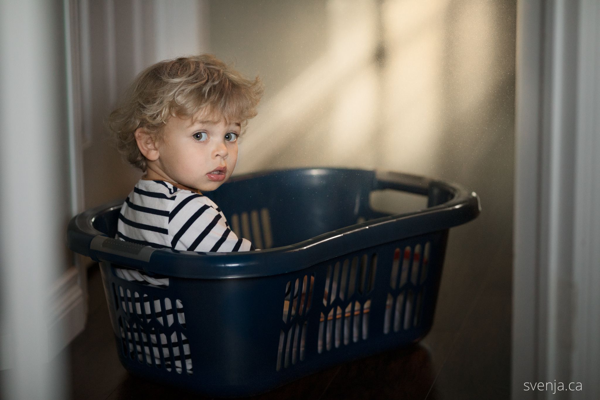 a boy sites in a clothes basket