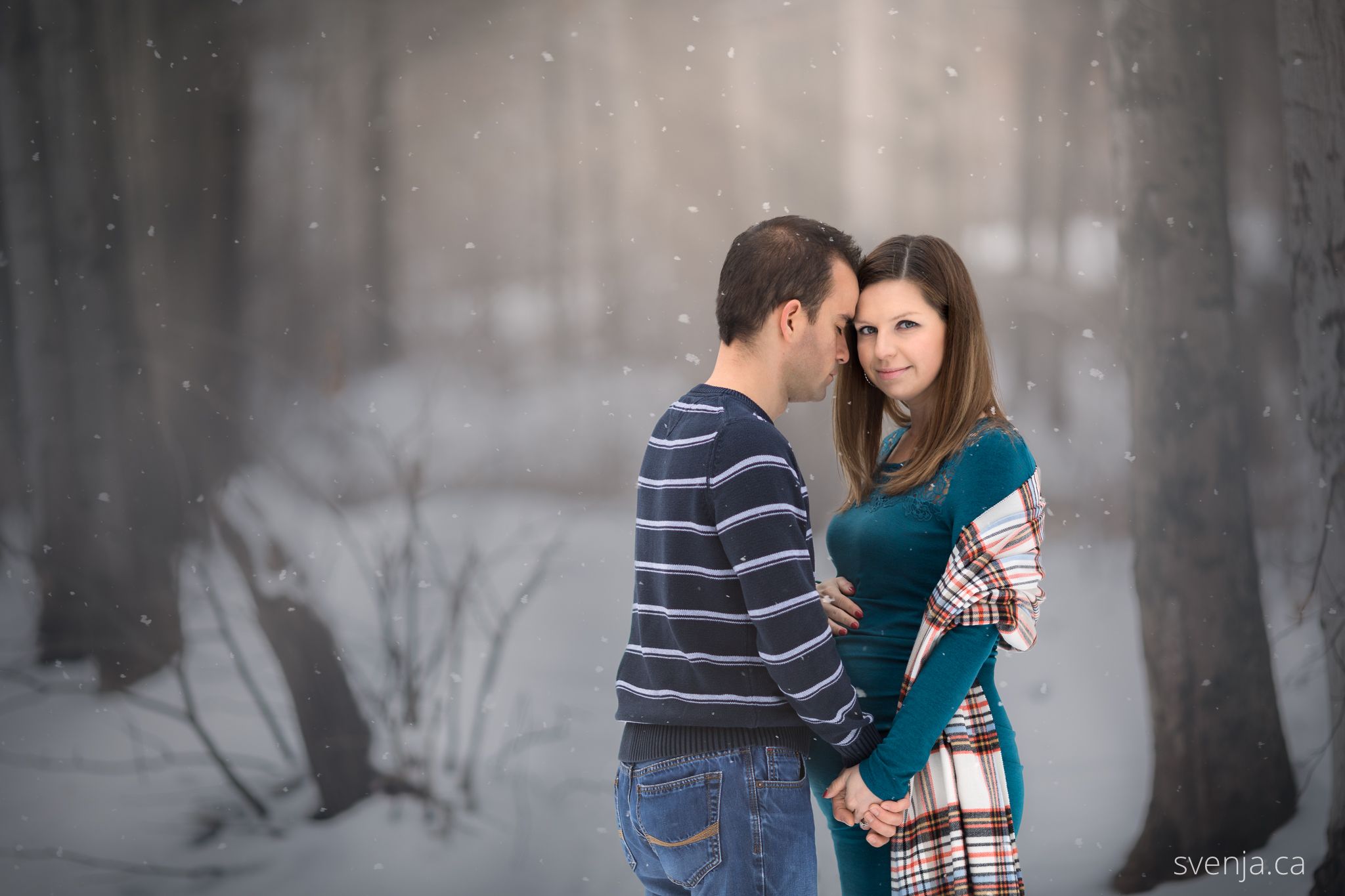 maternity photo of wife and husband in the forest with snow